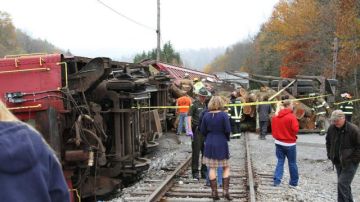 Equipos de emergencia asisten a las personas en el lugar donde un camión que transportaba troncos por Cheat Mountain en la Ruta 250 se estrelló contra un tren que tomaba pasajeros en el condado de Randolph, Virginia Occidental.