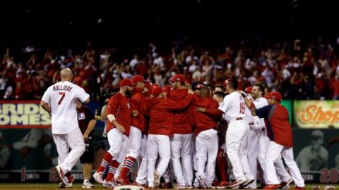 Carlos Beltrán es rodeado por sus compañeros de los Cardenales después de su hit de la victoria en el inning 13 del juego contra los Dodgers de Los Ángeles.