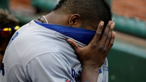 Yasiel Puig, de Dodgers, se tapa los ojos en el dugout durante la séptima entrada del Juego 2 de la serie ante los Cardenales de San Luis.