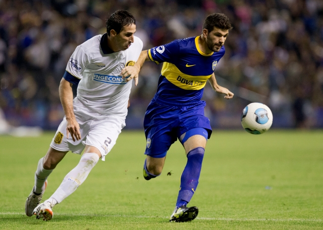 Boca Juniors' Emmanuel Gigliotti, right, vies for the ball with Rosario Central's Alejandro Donatti during an Argentina's league soccer match in Buenos Aires, Argentina, Sunday, Oct. 13, 2013. (AP Photo/Eduardo Di Baia)