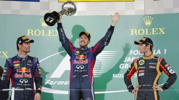 Sebastian Vettel, de Red Bull, levanta su trofeo tras conquistar el Gran Premio de Japón. Atestiguan Mark Webber (izq.) y Romain Grosjean.