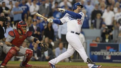 El jugador de los Dodgers de Los Ángeles, Adrian González (d), batea un doble contra los Cardenales de San Luis durante la cuarta entrada del tercer juego de las eliminatorias del Campeonato de la Liga Nacional.
