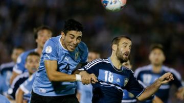 El uruguayo Jorge Fucile disputa el esférico con el argentino Rodrigo Palacio