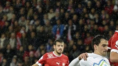 El jugador de Suiza, Haris Seferovic disputa un balón con el jugador de Eslovenia, Branko Ilic.