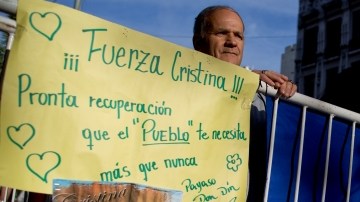 A man stands behind a fence where a banner reads in Spanish "Be Strong Cristina, recover soon because people need you more than ever" in support of Argentina's President Cristina Fernandez outside the Favaloro Hospital where she is undergoing surgery to her skull to siphon out blood that is pressuring her brain, months after she suffered an unexplained head injury in Buenos Aires, Argentina, Tuesday, Oct. 8, 2013. Fernandez was diagnosed with "chronic subdural hematoma," or fluid trapped between the skull and brain. (AP Photo/Natacha Pisarenko)