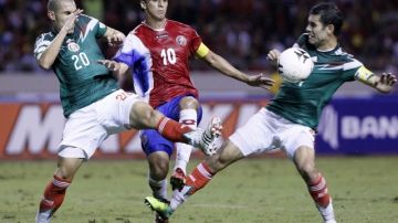 Bryan Oviedo de Costa Rica  (centro) disputa el balón con los mexicanos Rafael Márquez y Jorge Torres en partido clasificatorio al Mundial Brasil 2014.  Foto: Efe