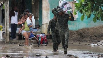 Un miembro del Ejército Mexicano ayuda a evacuar a una familia en la Costa Grande de Guerrero, México, debido a las fuertes lluvias del huracán "Raymond".