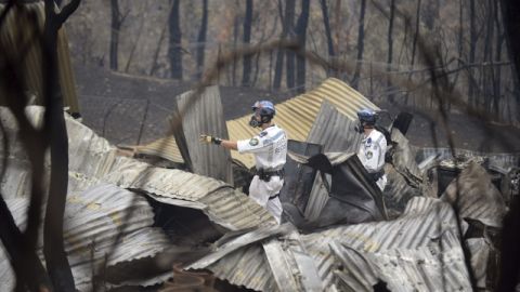 Miembros de rescatistas inspeccionan una propiedad destruida en uno de los incendios, en Nueva Gales del Sur, Australia, ayer.
