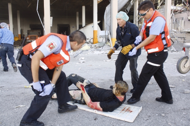 Trabajadores y rescatistas ayudaban ayer a un herido después de la explosión en la fábrica Dulces Blueberry, en Ciudad Juárez, México, ayer.