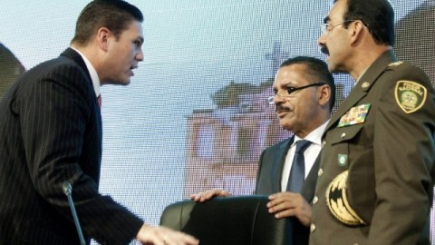 El ministro de Defensa de Colombia, Juan C. Pinzón (izq.), habla con el secretario de Interpol (cen.) y el director de la Policía de Colombia.