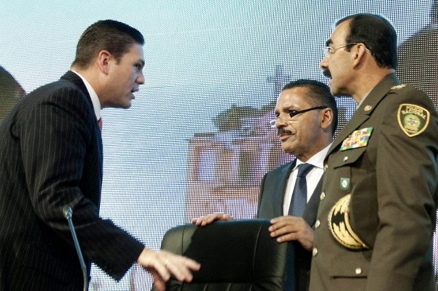 El ministro de Defensa de Colombia, Juan C. Pinzón (izq.), habla con el secretario de Interpol (cen.) y el director de la Policía de Colombia.
