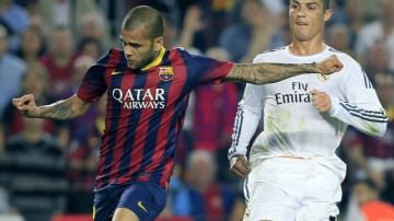 Dani Alves (i), del FC Barcelona, intenta rematar ante la oposición de Cristiano Ronaldo (d), del Real Madrid