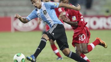 El argentino Joaquín Ibañez (izq.) controla el balón  ante el acoso de  Ali Musse  de Canadá durante el partido de ayer en Dubai.