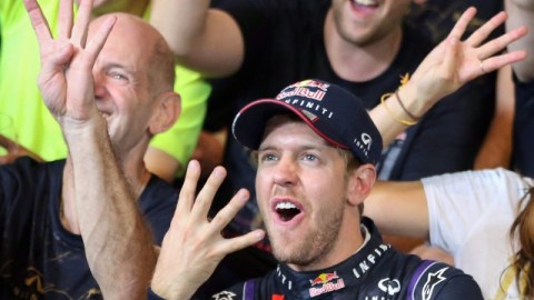El alemán de Red Bull, Sebastian Vettel, y parte de su equipo, muestran con sus manos el número de títulos de Fórmula Uno que ha ganado.