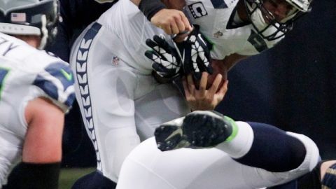 William Hayes, de los Rams, atrapa al quarterback de Seattle,   Russell Wilson, en el primer período del juego de ayer en San Luis.