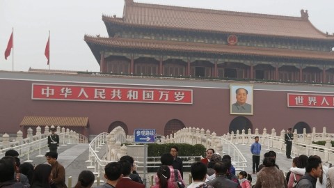 Un grupo de turistas se concentra delante de la entrada de la Ciudad Prohibida en la Plaza de Tiananmén, en Pekín (China).