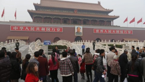 Un grupo de turistas se concentra delante de la entrada de la Ciudad Prohibida en la Plaza de Tiananmén, en Pekín (China).