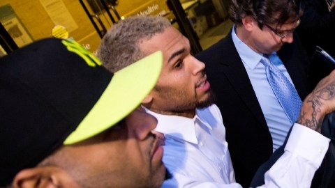 Guardaespaldas rodean a Chris Brown al salir el cantante ayer del tribunal en Washington. Un cargo de agresión contra el cantante fue reducido de delito grave a delito menor.