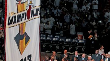 Los miembros del Heat observan cómo develan el enorme banderín de campeones absolutos  de la NBA edición 2012-2013.