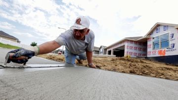 Un trabajador le da forma a una acera frente a un grupo de nuevas casas construidas en Omaha, Nebraska. Según un estudio del BPC, la reforma migratoria impulsaría el sector de la construcción.