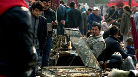 Vendedores uigures ofertan mercancías en mercado donde la Policía china ha estado pidiendo identificaciones tras ataque en Plaza de Tiananmen.