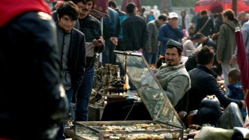 Vendedores uigures ofertan mercancías en mercado donde la Policía china ha estado pidiendo identificaciones tras ataque en Plaza de Tiananmen.