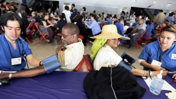 La guatemalteca Maria Orantes (al centro) se chequea la presión arterial como parte del evento organizado por 'Care Harbor'.