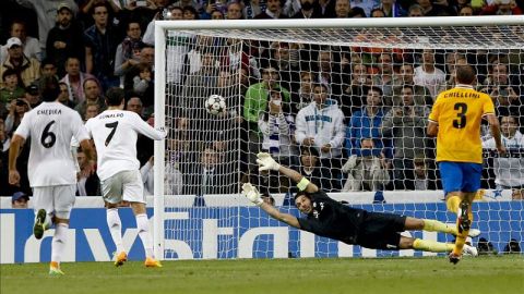 El delantero portugués del Real Madrid Cristiano Ronaldo (2i) marca de penalti ante el portero del Juventus de Turín Gianluigi Buffon (2d) el segundo gol para el conjunto blanco, durante el partido de la fase de grupos de Liga de Campeones disputado en el estadio Santiago Bernabéu.