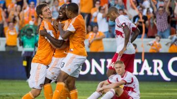 Omar Cummings (centro) festeja con sus compañeros tras anotar ayer el gol que dio vida al Dynamo para la vuelta en Nueva York.