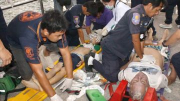 Rescatistas proveen primeros auxilios a personas  luego del hundimiento del barco.