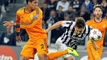 El delantero español de la Juventus Fernando Llorente (c) remata de cabeza para conseguir el 2-2 ante los defensas del Real Madrid Ramos (dcha) y Varane