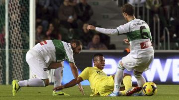 Ikechuwku Uche (caído), pugna por un balón con Rubén Pérez  y David Rodríguez durante el encuentro disputado   ayer en Elche.