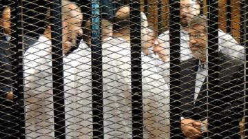 El  depuesto presidente de Egipto, Mohamed Morsi (der.) y  otros acusados en la primera sesión del juicio que se le sigue.