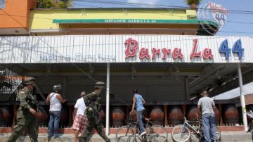 Policías pasan junto al club La Barra de la 44 en Cali, Colombia, donde 8 personas murieron y 7 resultaron heridas en una balacera.