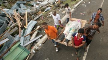 Miembros de la localidad de Tacloban llevan a una de las víctimas del paso del tifón Haiyan.