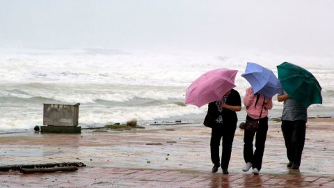Personas caminan por una playa en la ciudad de Danang, en Vietnam, donde se espera que el tifón Haiyan llegue este lunes.