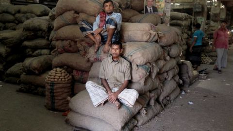 Comerciantes se sientan sobre sacos en un mercado al por mayor en el segundo día de una huelga general, en Dhaka, Bangladesh.