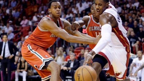 Mario Chalmers (der.) pelea por el balón con  Caron Butler, al centro Brandon Knight, apoya a su compañero de Milwaukee.