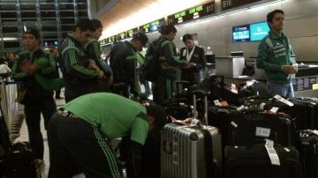 Jugadores de la selección mexicana documentan para transbordar hacia Sidney en el aeropuerto angelino.