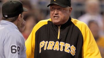 Clint Hurdle (d), director de los Piratas de Pittsburgh, discute con el umpire Chris Guccione después de que un lanzamiento estuvo a punto de golpear al jugador Kevin Correia.