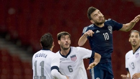 El escocés Robert Snodgrass cabecea  la pelota entre Alejandro Bedoya (izq.) Brad Evans  y Omar González de Estados Unidos.