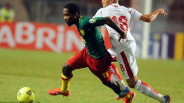 Jean Makoun (izq.), autor de dos goles para Camerún, escapa a la marca del tunecino Yassin Mikeri .