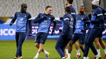 Franck Ribery (segundo de la izq.i) calienta junto a sus compañeros en el Estadio de Francia de Saint-Denis.