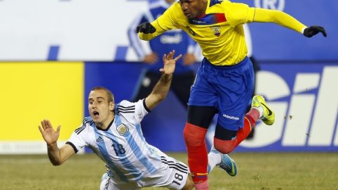 El argentino Rodrigo Palacio (18) cae mientras es marcado por el ecuatoriano Frickson Erazo (3), durante el amistoso que terminó sin anotaciones.