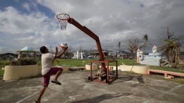 Michael Velasco juega en un improvisado aro en el parque destruido de Tacloban.