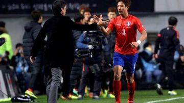 Hong Jeong-ho es felicitado por el DT Hong Myung-bo, de Corea del Sur, tras anotarle a Suiza.