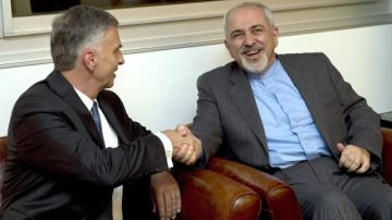 Didier Burkhalter (i), ministro de Exteriores de Suiza, le la da mano a su contraparte de Irán Mohammad-Javad Zarif durante un encuentro en el Hotel Intercontinental previo a las negociaciones sobre el programa nuclear iraní, en Ginebra, Suiza.