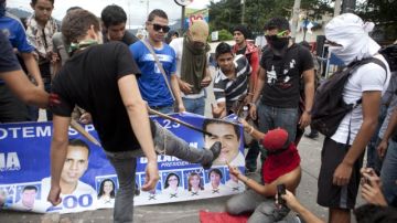 Jóvenes manifestaban  que hubo fraude y  protestaban ayer ante  la Universidad Nacional Autónoma de Honduras, en Tegucigalpa.