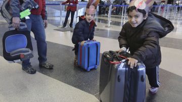 Llevando unos sombreritos de pavo, los hermanitos Rishi Chandra, de 5 años, y Ravi, de 3, empujaban sus maletas este miércoles en el aeropuerto de O'Hare en Chicago.
