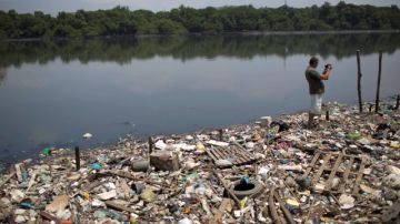 El biólogo Mario Moscatelli toma fotografías de basura que flota sobre el Canal de Fundao, en Río de Janeiro, Brasil.